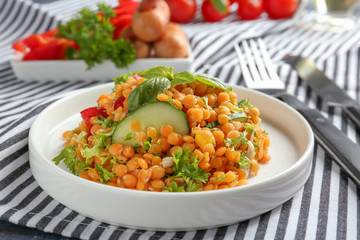 Plate with delicious lentils salad on kitchen table