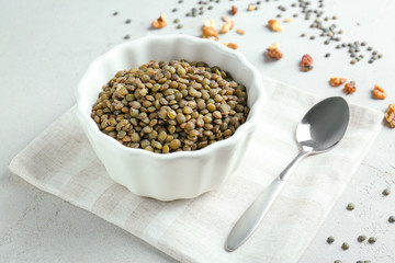 Dish with tasty lentil porridge on table
