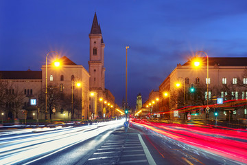 Fototapeta na wymiar Ludwigstrasse avenue with light tracks and Church St. Louis, called Ludwigskirche, during evening blue hour in Munich, Germany