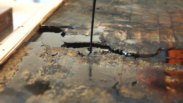 the carpenter, joiner, woodworker pours black epoxy resin from the maple top
