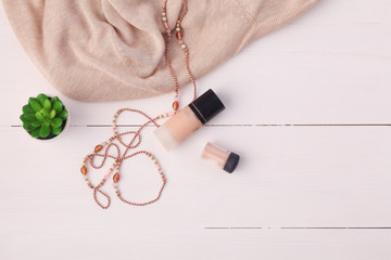 Woman clothing and accessories placed on a wooden background.