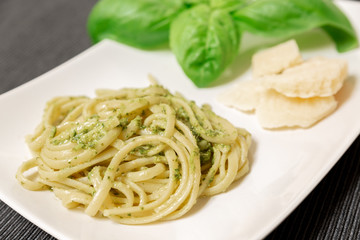 Linguine (or Trenette) with Genovese pesto sauce, a typical sauce of the Liguria region (Italy). The basil is the fundamental ingredient of this delicious sauce together with Parmesan cheese.