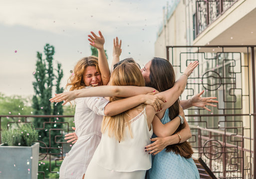 Girls Party. Beautiful Women Friendship on the balcony or roof At Bachelorette Party during sunset. They are hugging