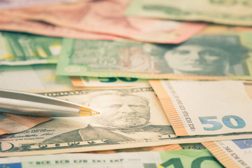 Obraz na płótnie Canvas Close-up pen on USD dollar AUD and EUR bill, Business concept a pen and banknote with shallow DOF