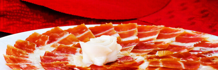 plate with cut slices of jamon serrano, traditional Spanish ham