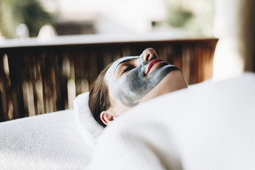 Woman relaxing with a facial mask at the spa