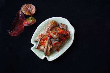 Stir fried eggplants in chili dressing isolated in black background captured flat lay top angle.