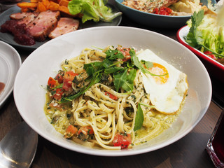 Arugula, parmesan & pesto pasta on wooden table
