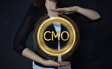 In the hands of a businessman, a neon circle with the inscription:CMO