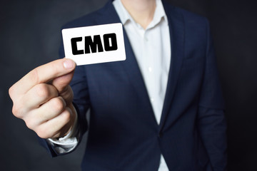 Businessman shows business card with the inscription:CMO