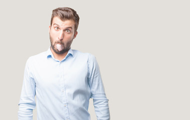 young handsome man joking and showing his tongue,blue t shirt, happy expression . person isolated...