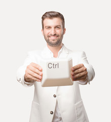 young handsome businessman holding a control key of a keyboard, wearing white blazer. person...