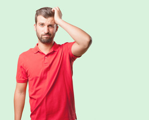 young handsome man confused wearing  red polo shirt . person isolated against monochrome background