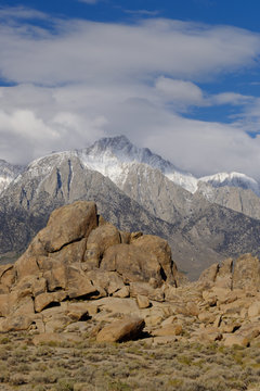 Vertical images of The Rugged and carved granite boulders of Alabama Hills with the Eastern Sierra Mountains and Mt Whitney Eastern California in the background