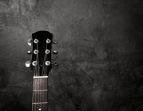 Close up acoustic guitar on a black background, with copy space for texture.