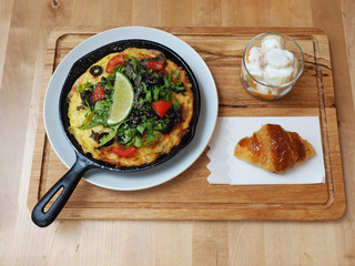 Classic Italian frittata with tomatoes and herbs in the pan