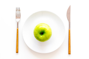 Proper nutrition with dietary fibre for weight loss. Apple on plate near measuring tape on white background top view