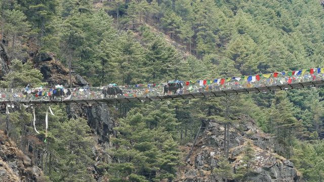 Largest suspension bridge in Solu Khumbu valley with colorful prayer flags, trekking area to the base camp of Everest peak (8848 m).