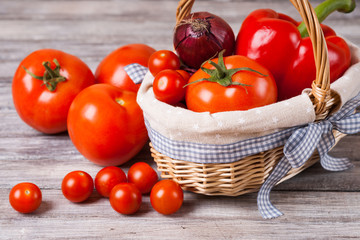 Cherry tomatoes, tomatoes, onion, bell pepper in a wicker plate 