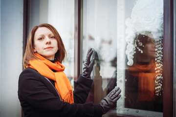 Portrait of a young woman in a black coat and red scarf in the city