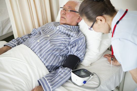 看護師に、血圧を測っている老人。