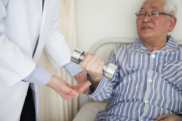 Obraz premium 病院で、リハビリをしている患者と、補助をしている医師。