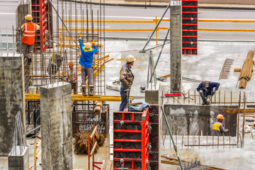 Construction workers are working on a construction site in Kiev, Ukraine. Concrete construction works and assembly of metal structures are carried out.