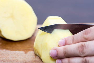 The woman cutting the potato