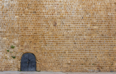 old iron door in the huge ancient wall.