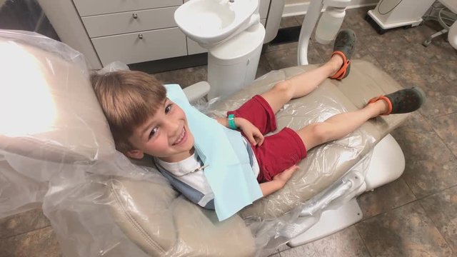 Little boy giving thumbs up in dentist chair