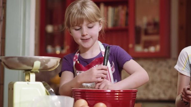 Young Girl Mixing Ingredients in a large Red Mixing Bowl in a Classic Kitchen Setting