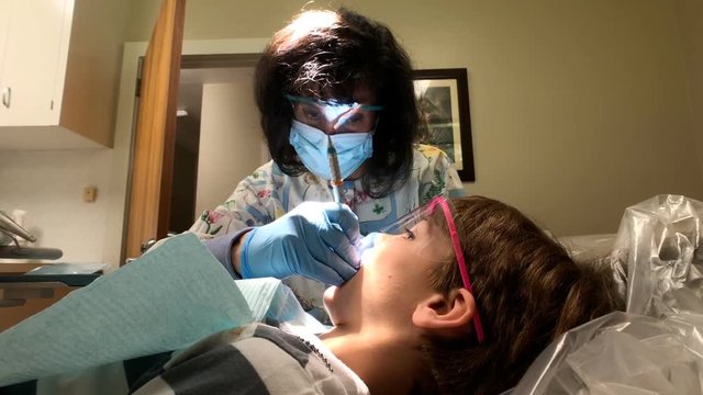 Little boy getting teeth cleaned at dentist office