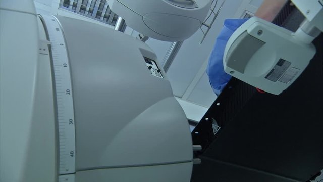 Low angle view of a linear accelerator cancer radiation machine spinning around a patient.