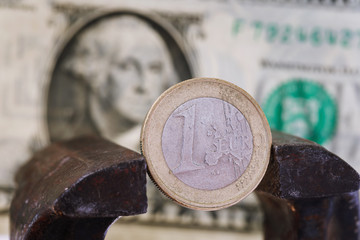 Financial dominance: one euro in a vice against the background of the American dollar with space for text