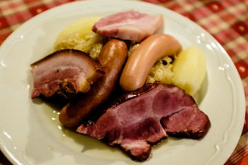 Choucroute garni, a typical alsacian plate, with sausages, bacon, choucroute and potatoes