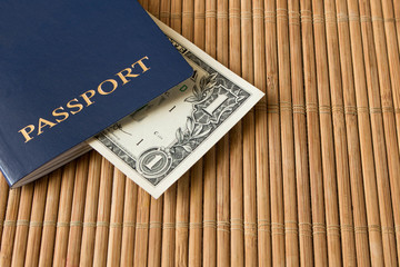 1 dollar bill in a blue passport on a bamboo napkin
