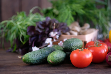 Vegetable.Fresh vegetables: tomatos, cucumbers,peppers,mushrooms ,onions and green seasonings on  old rustic oak table.