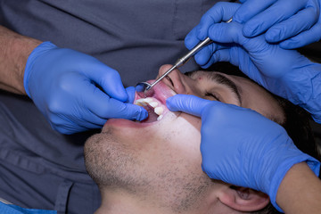 Young man at the dentist, to perform a dental implant