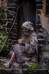 Fototapeta na wymiar Man, dressed in rags, begging through the streets of a village