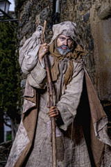 Naklejka premium Man, dressed in rags, begging through the streets of a village