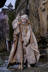 Obraz premium Man, dressed in rags, begging through the streets of a village