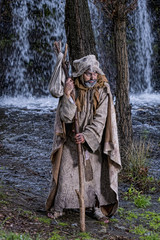 Man, dressed in rags, begging through the streets of a village