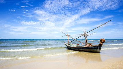 Fototapeta na wymiar Fishing boat on a beach and deep bluesky background , landscape Thailand