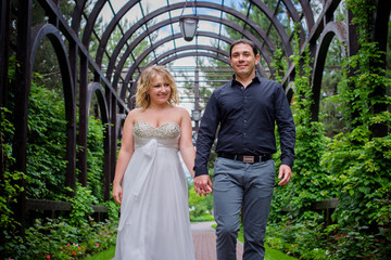 Romantic tenderness bride and groom at park. Young lady plus size enjoying moments in summer time. Beautiful bride posing with groom in her wedding day, pretty girl in a wedding dress 