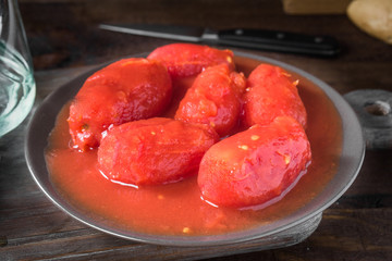 raw peeled whole tomato on wooden board