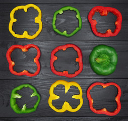Fresh vegetables, red, yellow, green sweet peppers on dark wood background.