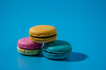 Macarons on cyan background clouseup.