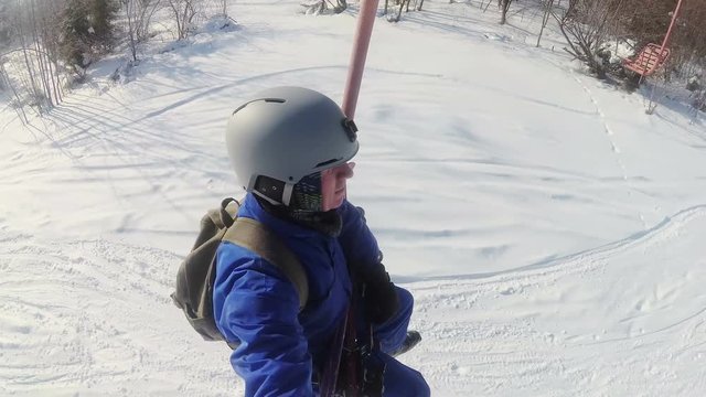 

4K.Man skier in  helmet sit on ski lift in sunny day.Selfie
