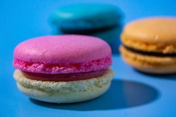 Macarons on cyan background clouseup.