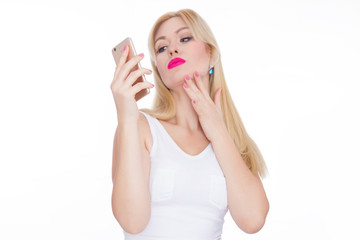 Beautiful blonde woman making selfie on phone. Girl in white dress on white background